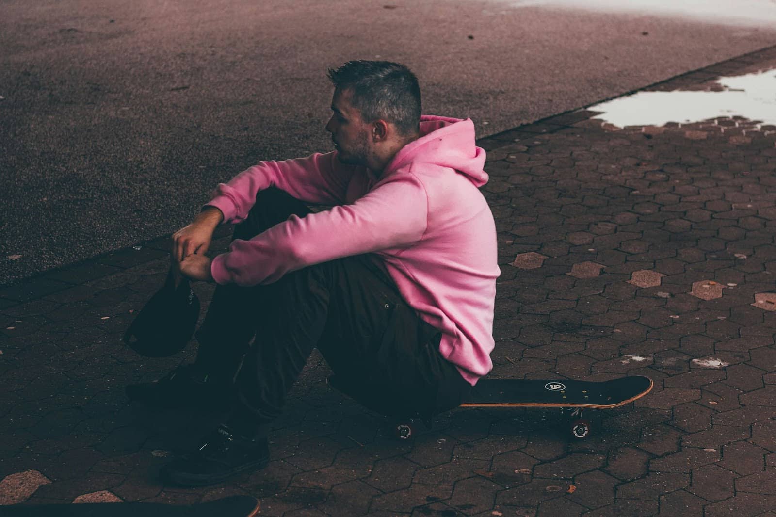 A man sitting on a skateboard.