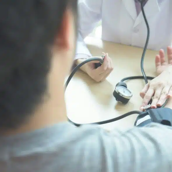 A doctor checking a man’s blood pressure.