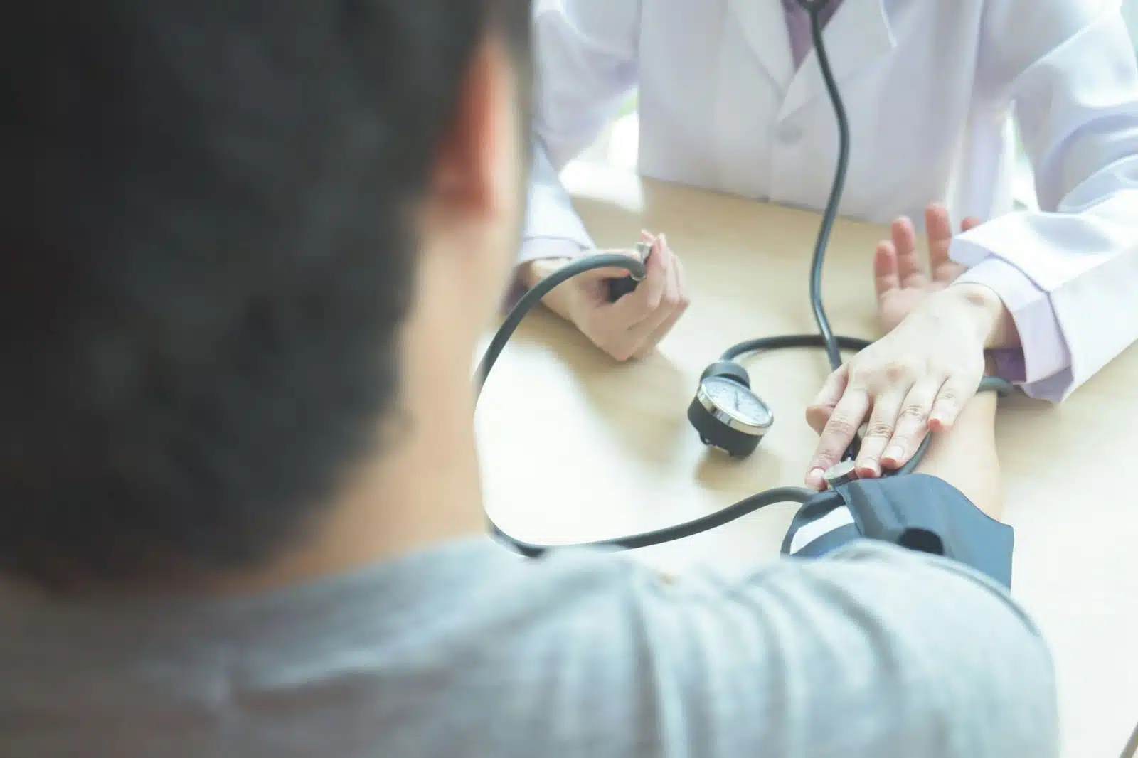 A doctor checking a man’s blood pressure.