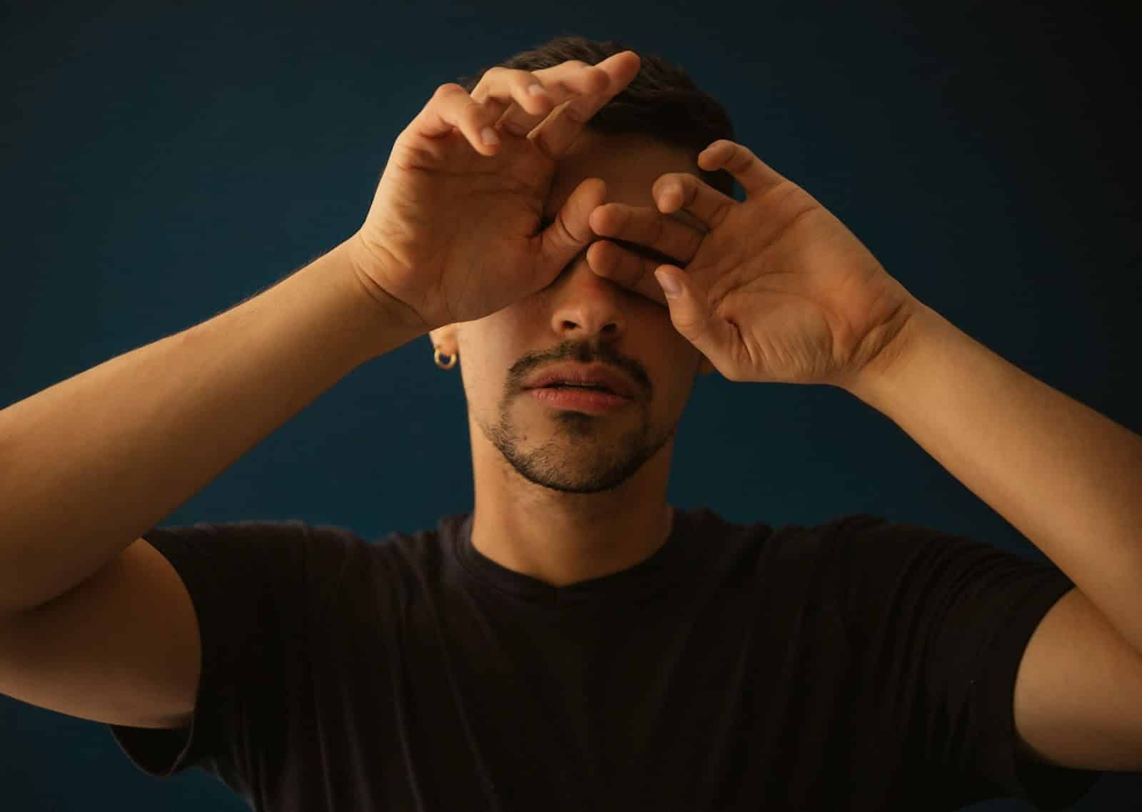 A man with a hands on his face.