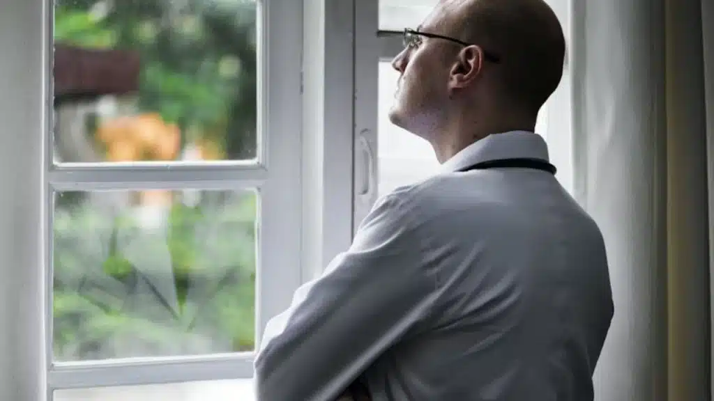 Man looking out a window deep in thought