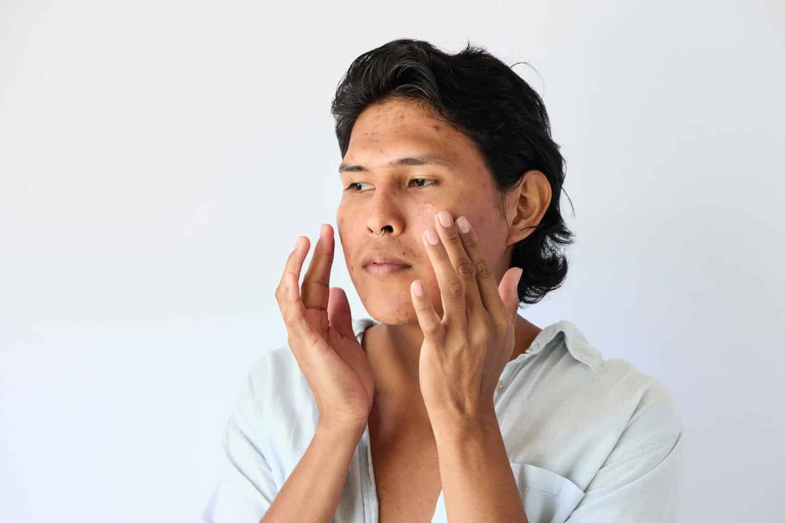 A man touching his face.