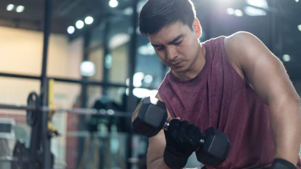A man lifting weights in a sleek modern gym