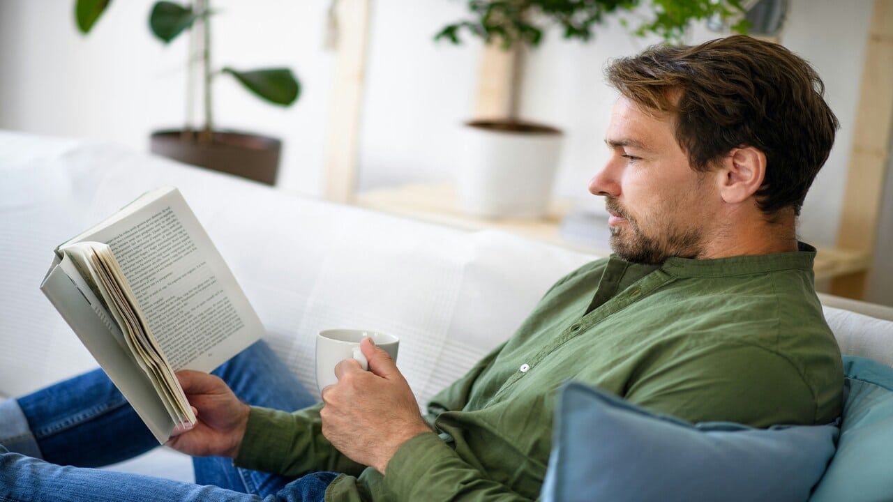 A man reading a book at home.