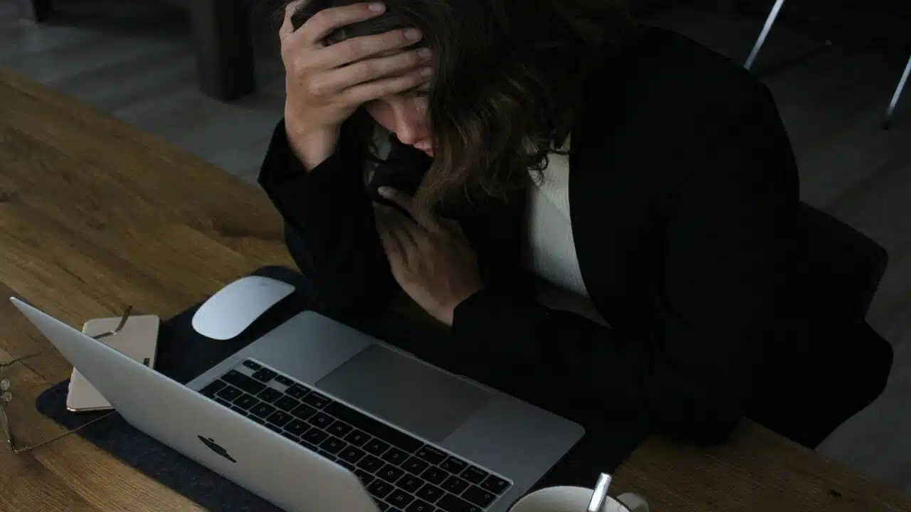 A woman looking stressed at work.