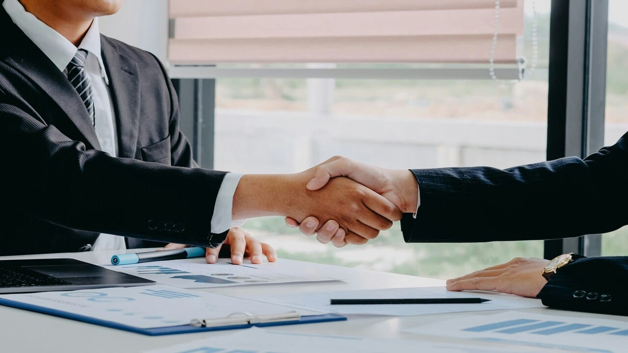 Two people shaking hands at work.