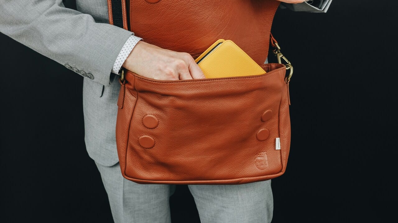 A person hiding his notebook in his bag