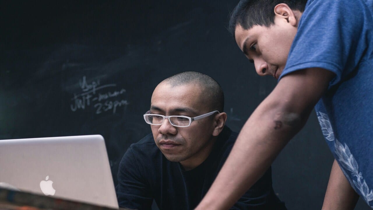 Two men working on something together.