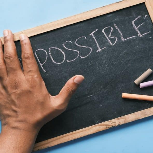 A chalkboard with the word “possible” written on it.