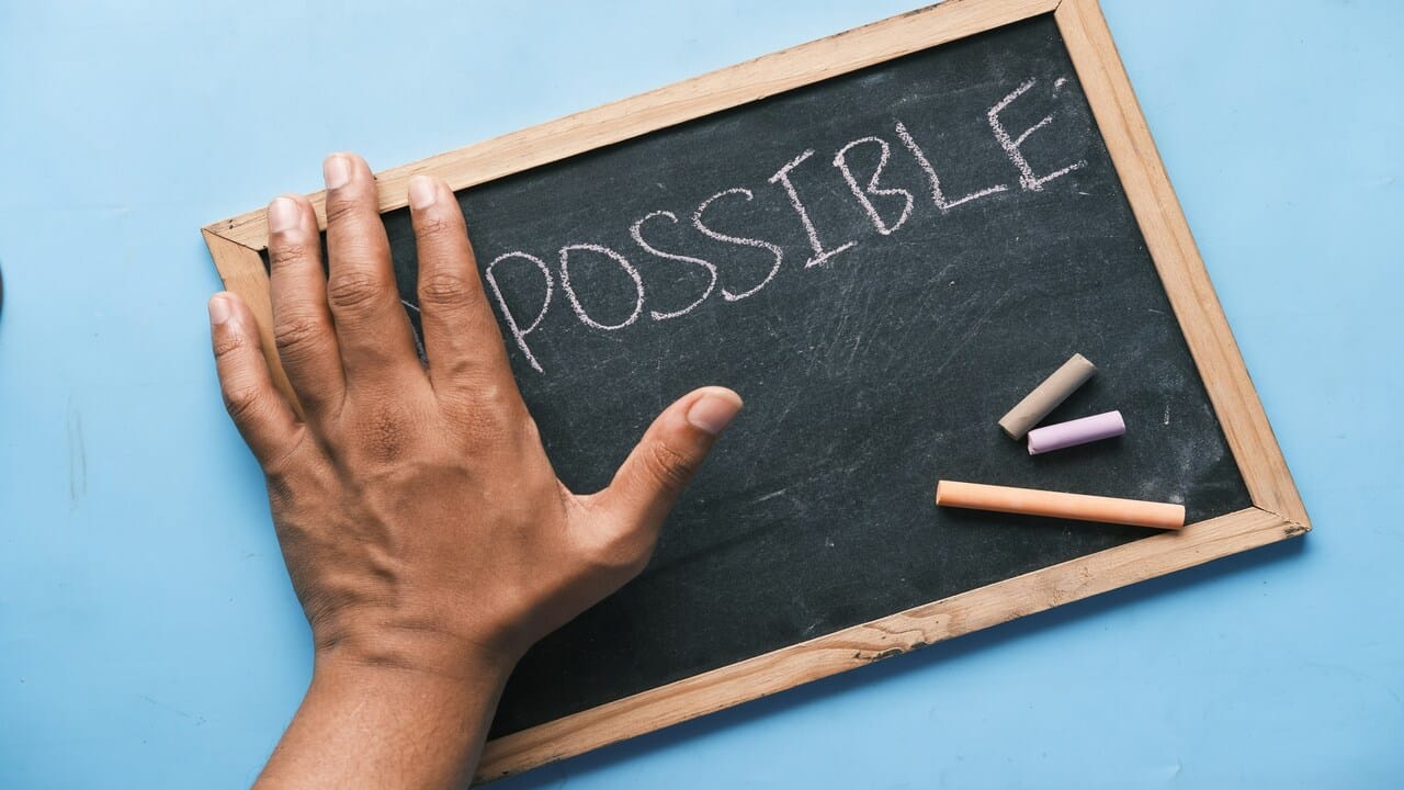 A chalkboard with the word “possible” written on it.