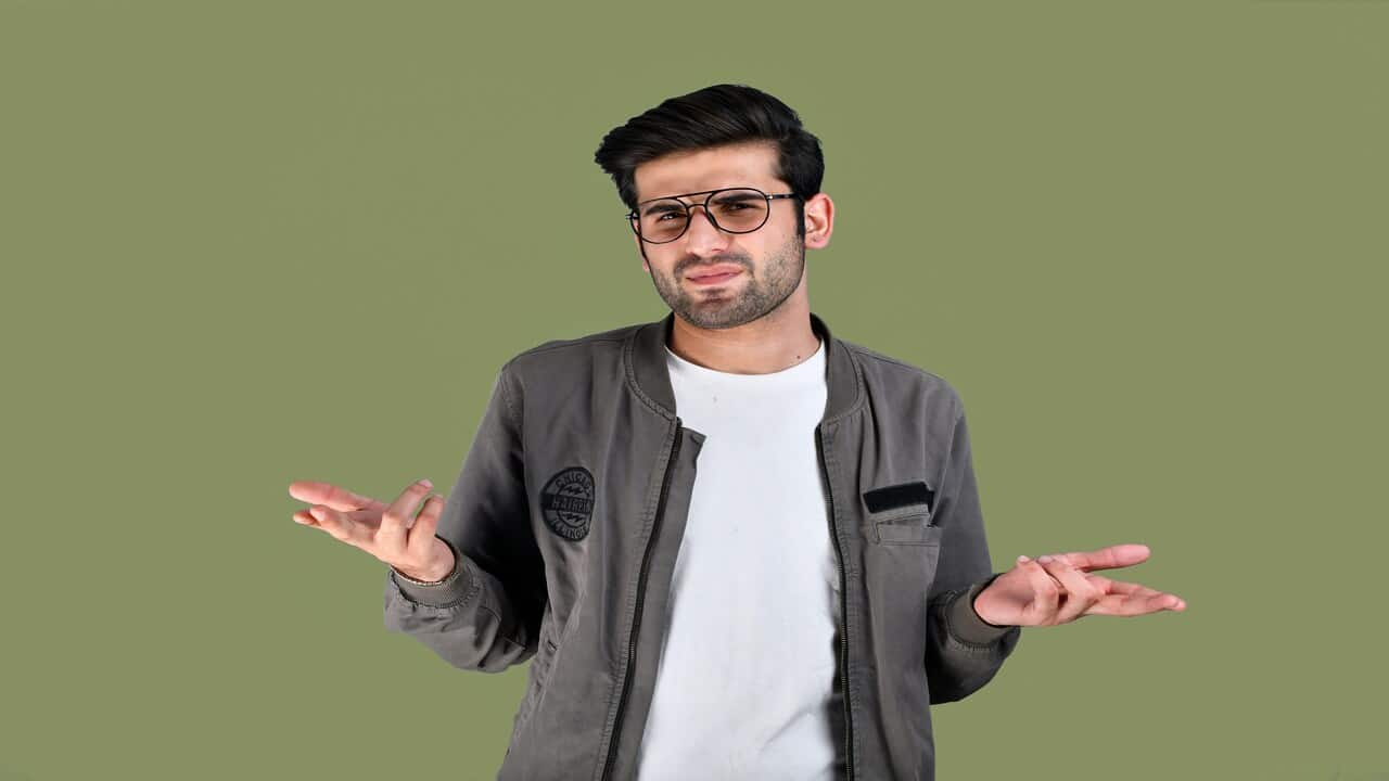 A man wearing glasses while explaining.