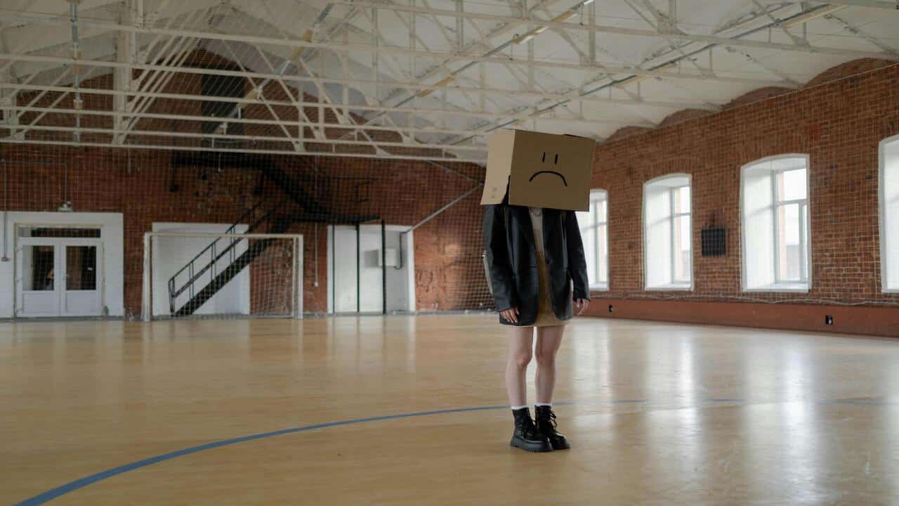 A girl with a brown box on her head.