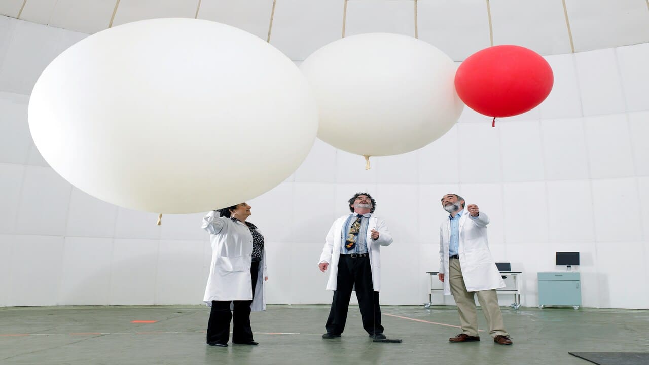 Three people holding different types of balloons.
