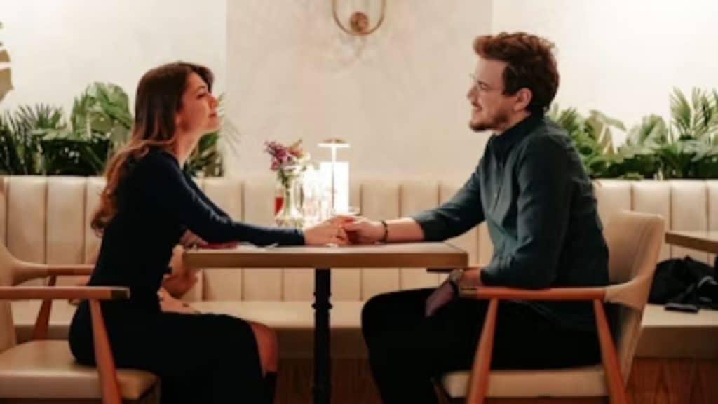 Couple seated at a kitchen table, calmly discussing while making eye contact.