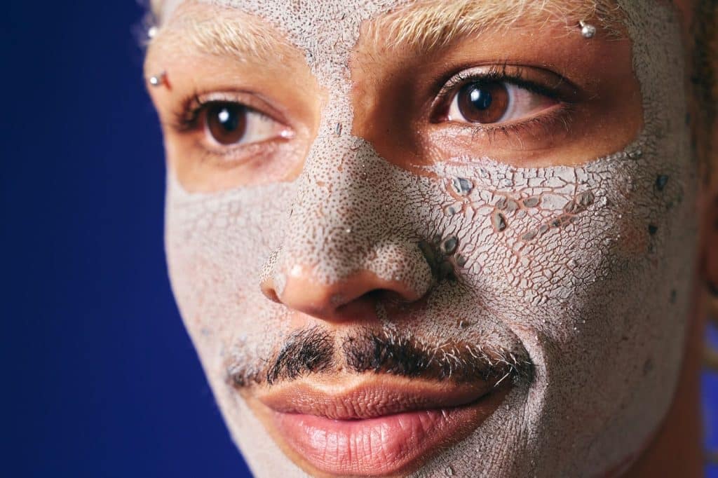 A man exfoliating his face.