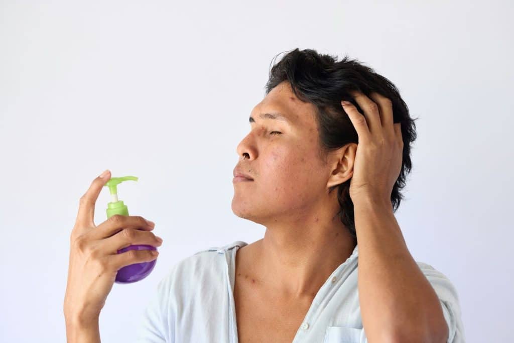 A man spraying something at his face.