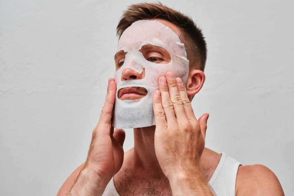 A man covering his face with facial mask.