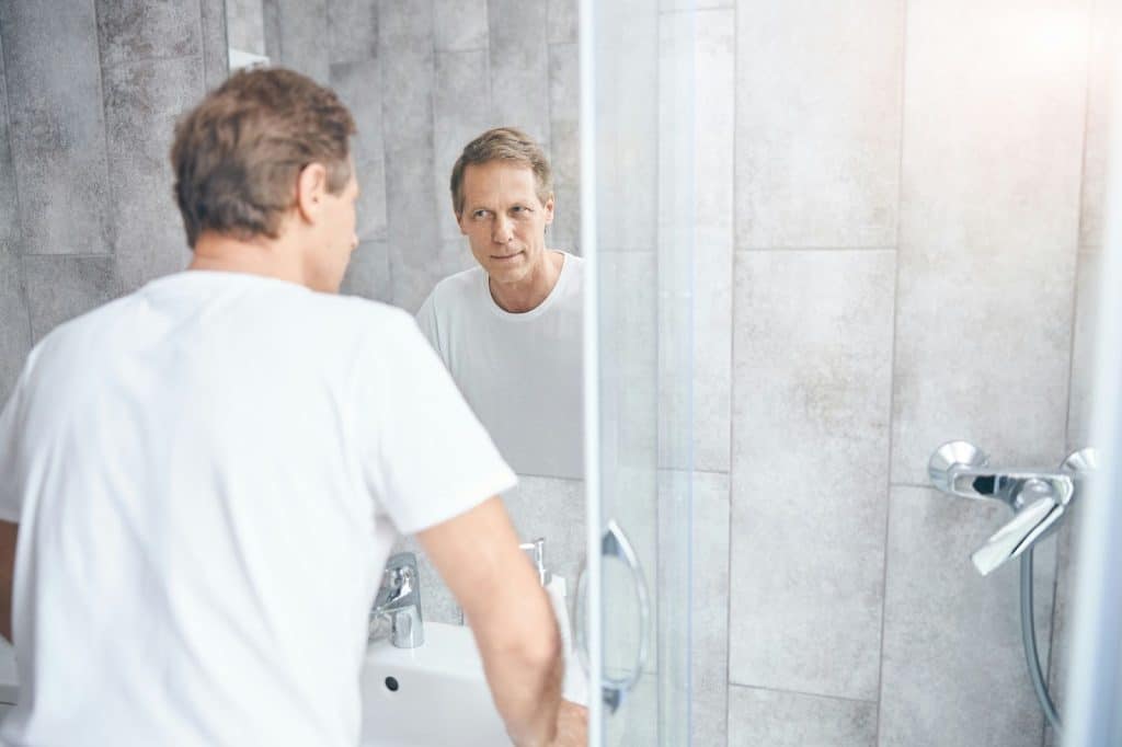 A man looking at the mirror.
