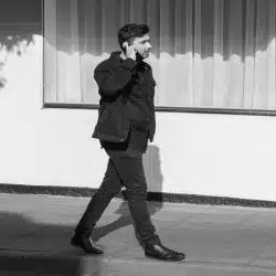 A man walking down the street and using his phone.