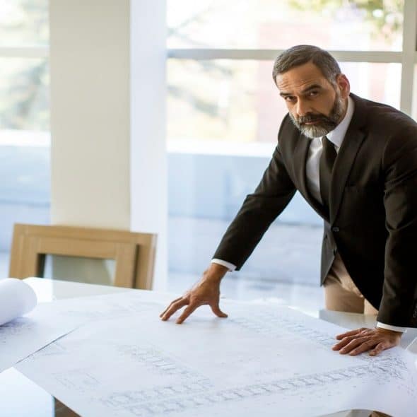 A man checking blueprints in the office.