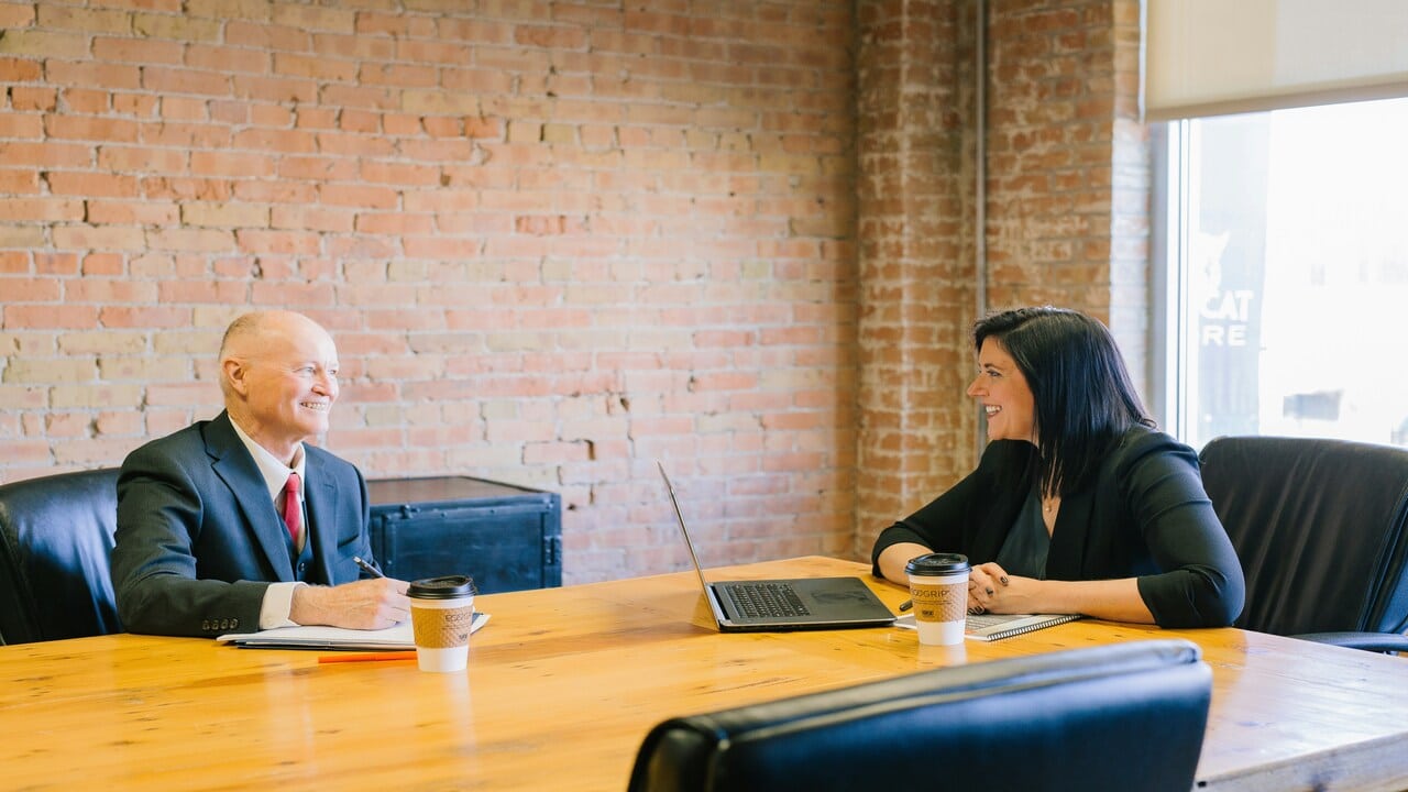 A man and a woman talking at the office.