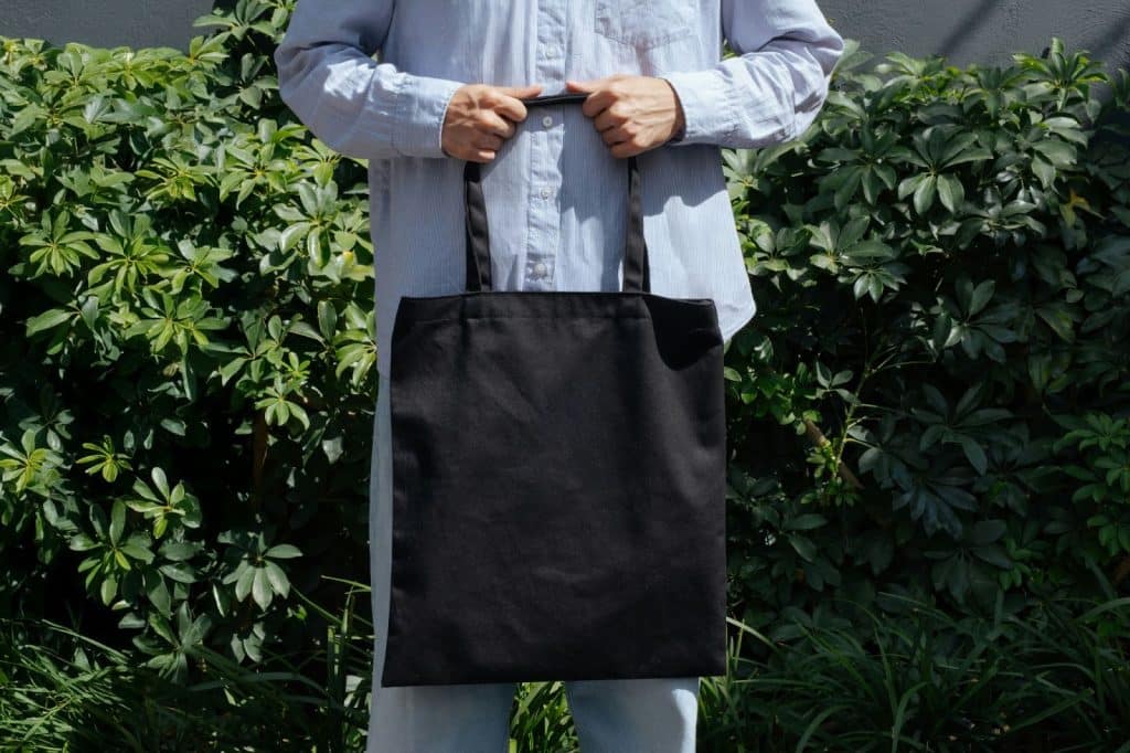 A picture of a man carrying a tote bag to represent “carry”.