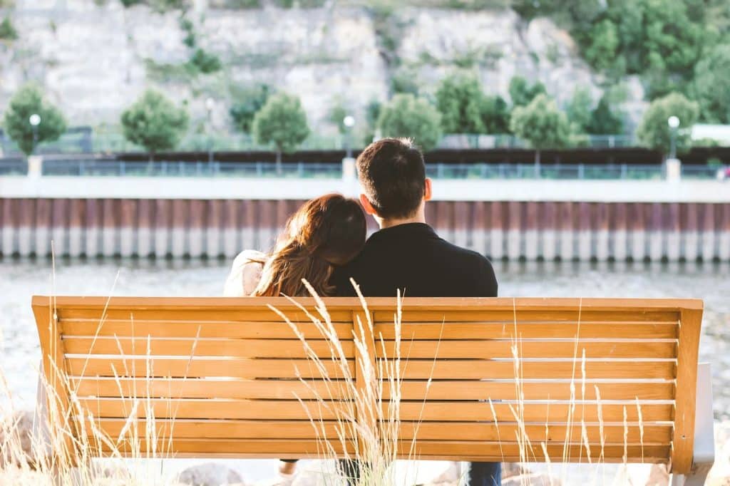 A man and woman sitting at the bench.