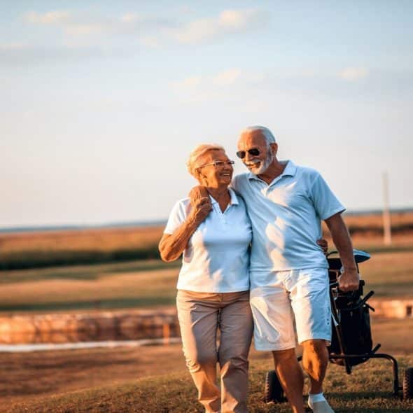 An older couple golfing together