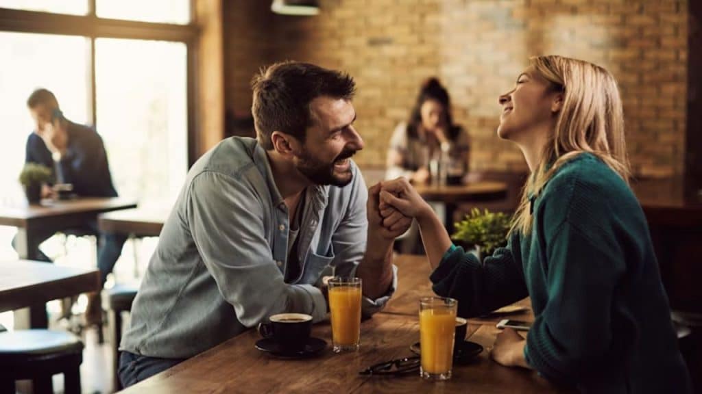 Man and woman laughing together while discussing their relationship