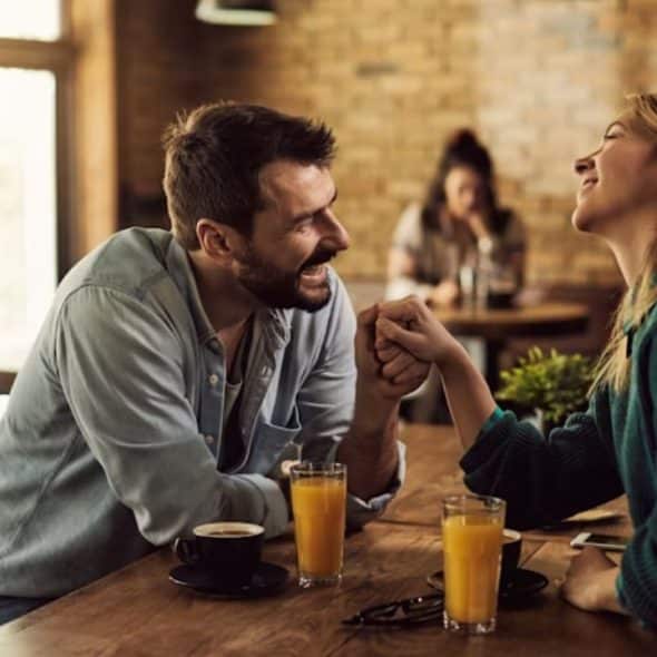 Man and woman laughing together while discussing their relationship