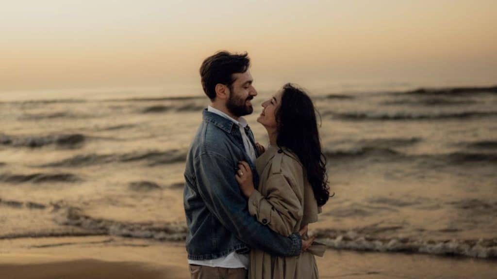 Couple embracing by the ocean, symbolizing connection