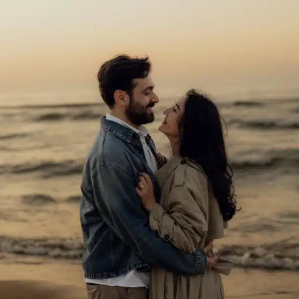 Couple embracing by the ocean, symbolizing connection