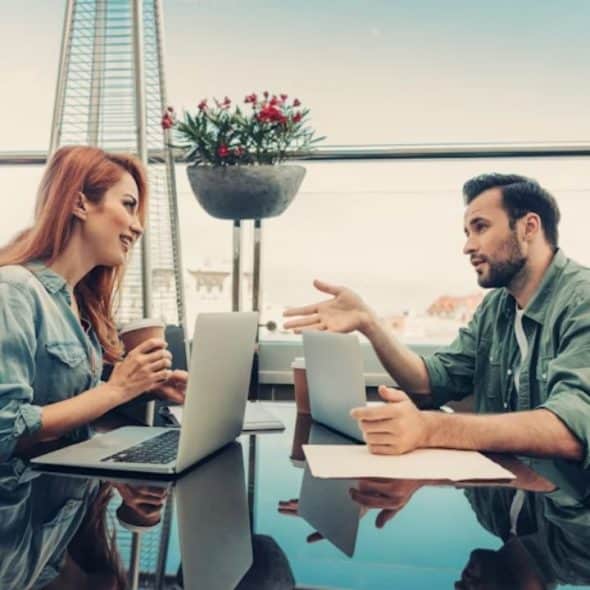 Couple sitting on a rooftop discussing goals over coffee