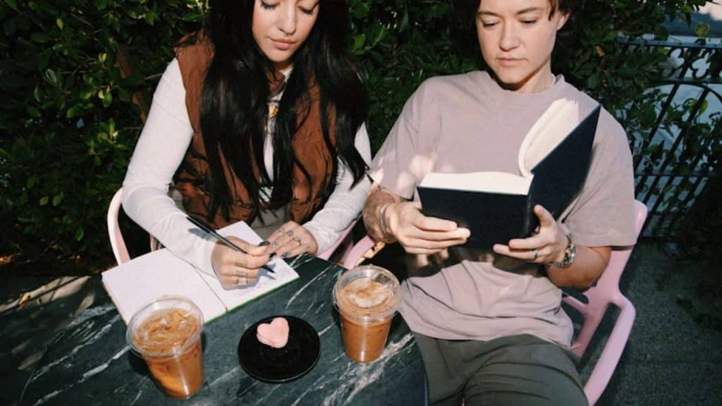 Couple sitting at a table with tea and journals