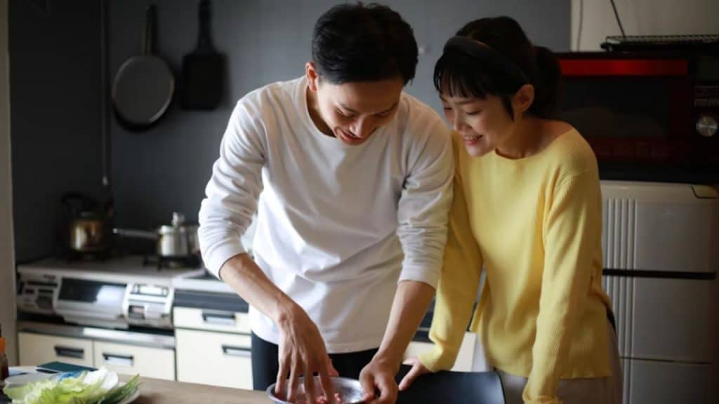 Couple cooking dinner side by side