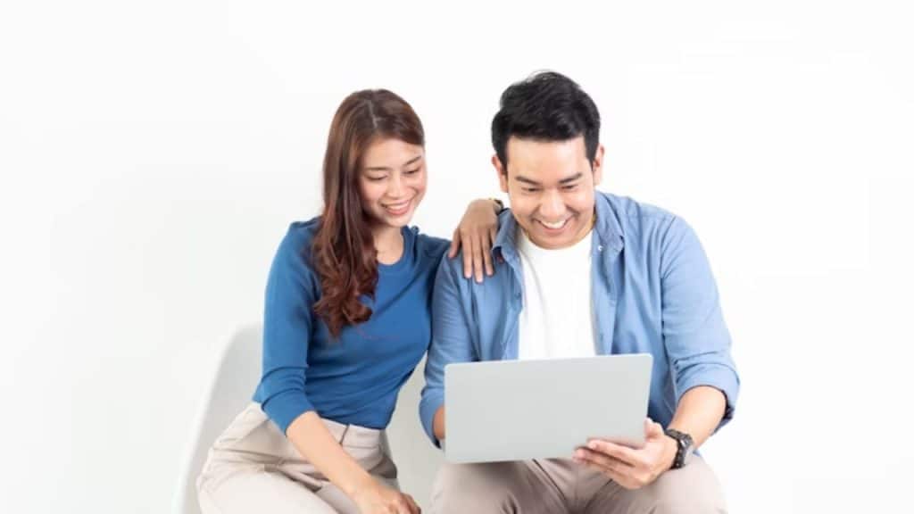 Couple looking at long term financial plans on laptop and calendar.