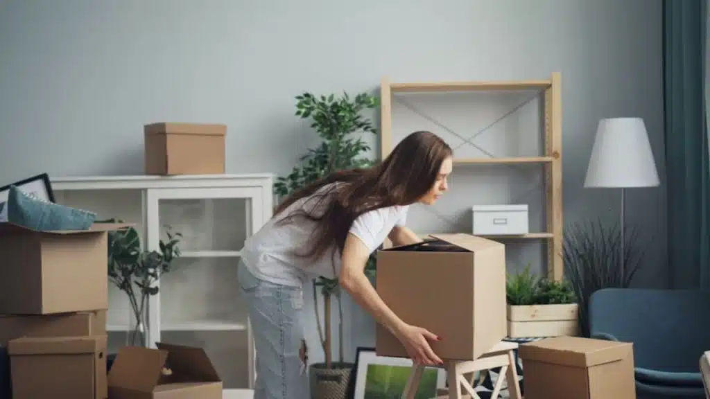 Woman moving heavy boxes at home