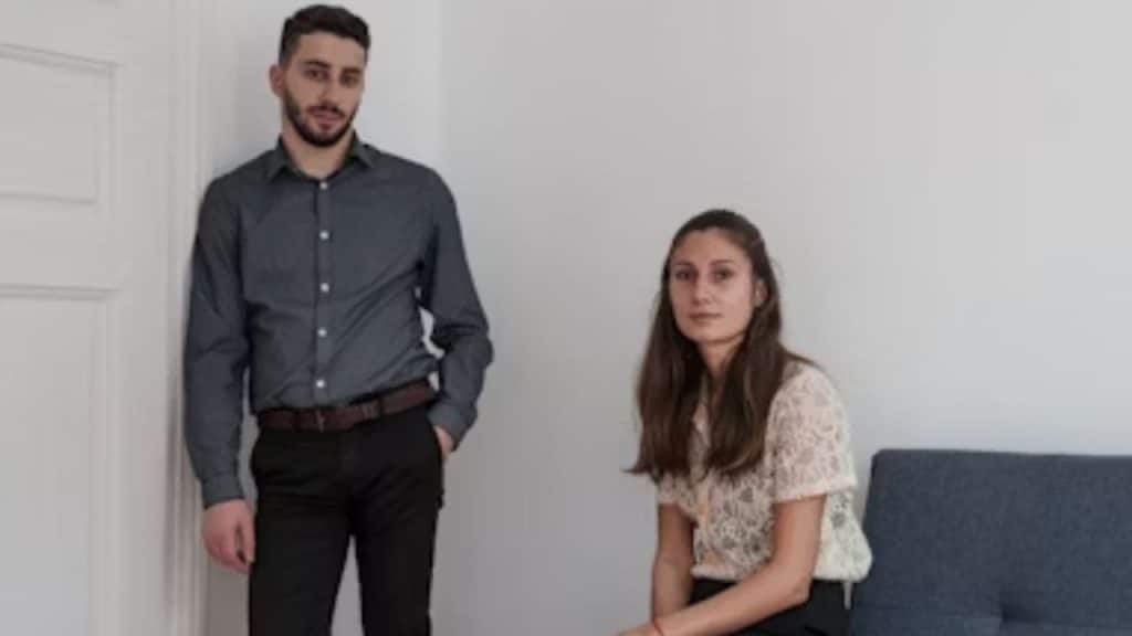 Couple looking frustrated but thoughtful in a modern apartment.