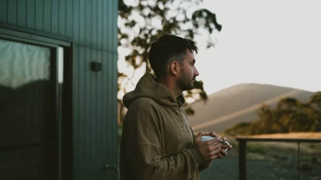 Man looking pensive while staring into the distance during sunset.