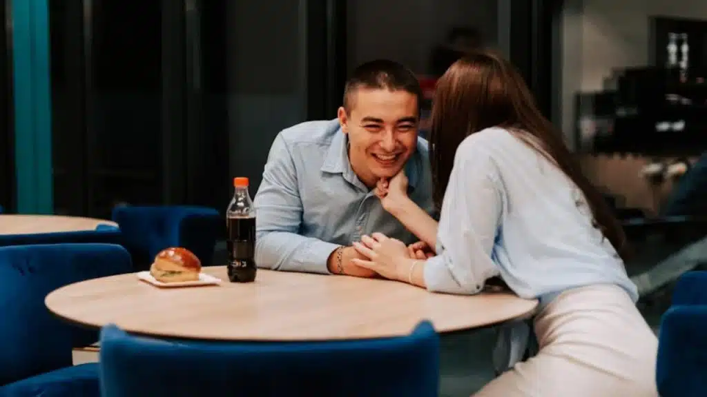 Man smiling sincerely while having a low-key chat with his partner.