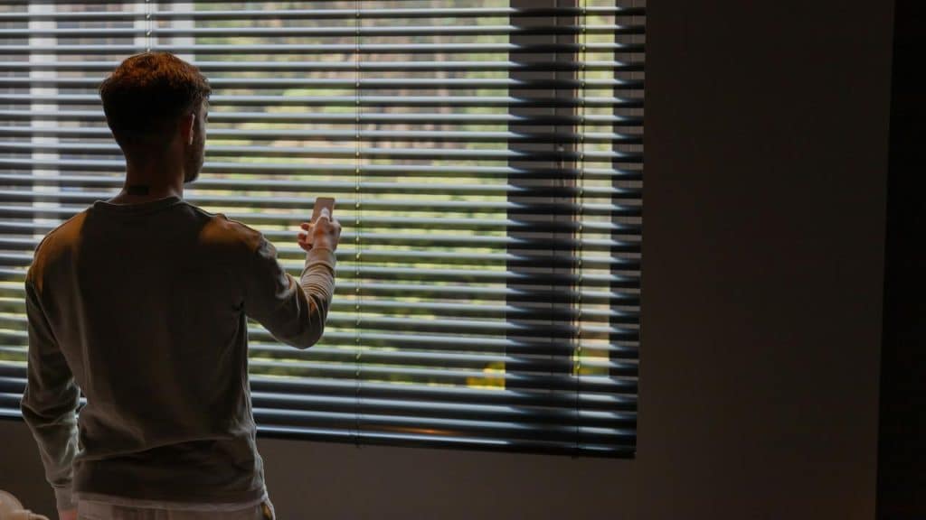 A man staring at the view outside from a window.