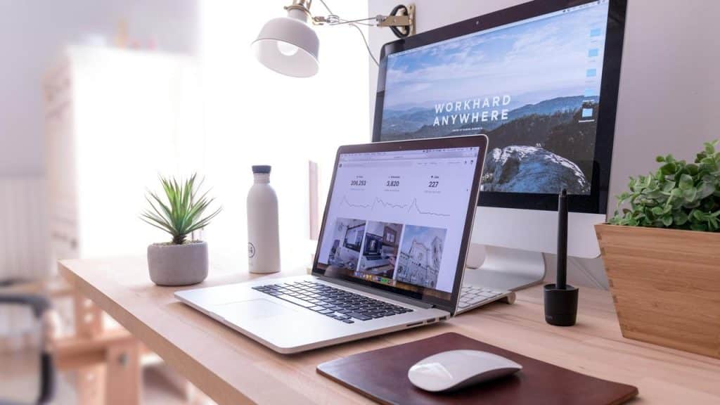 A modern desk with a laptop showing analytics beside a larger monitor.
