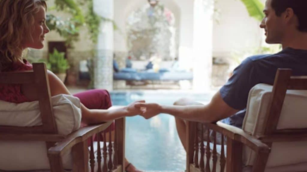 Couple sitting together quietly, holding hands in the morning.