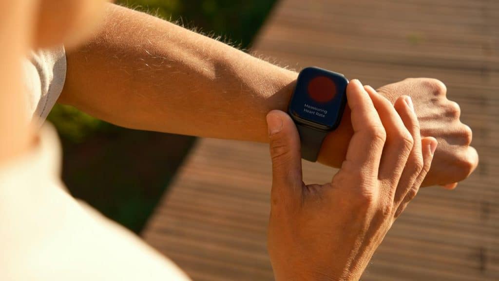 A person checking a heart-rate smartwatch on their wrist.