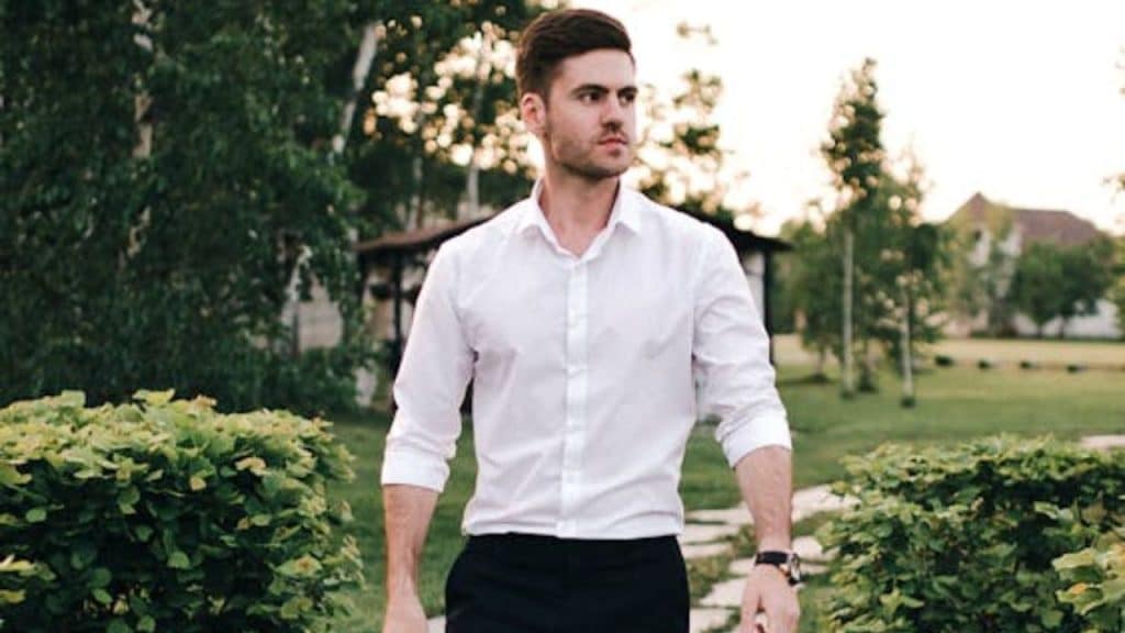 Man walking confidently in a park, looking peaceful and self-assured.