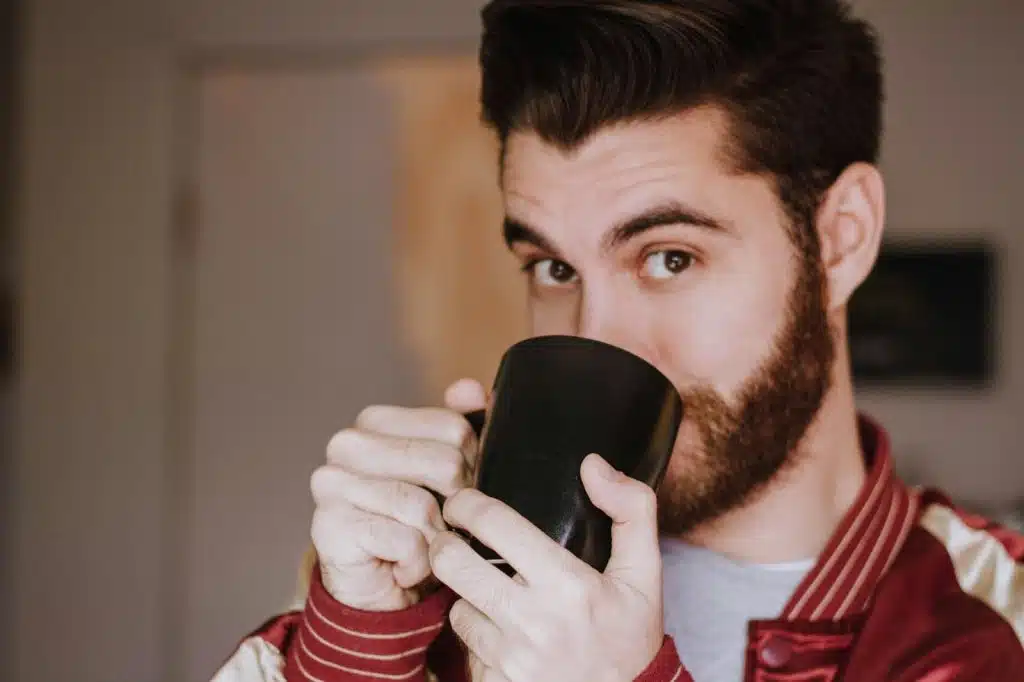 A man drinking a hot coffee.