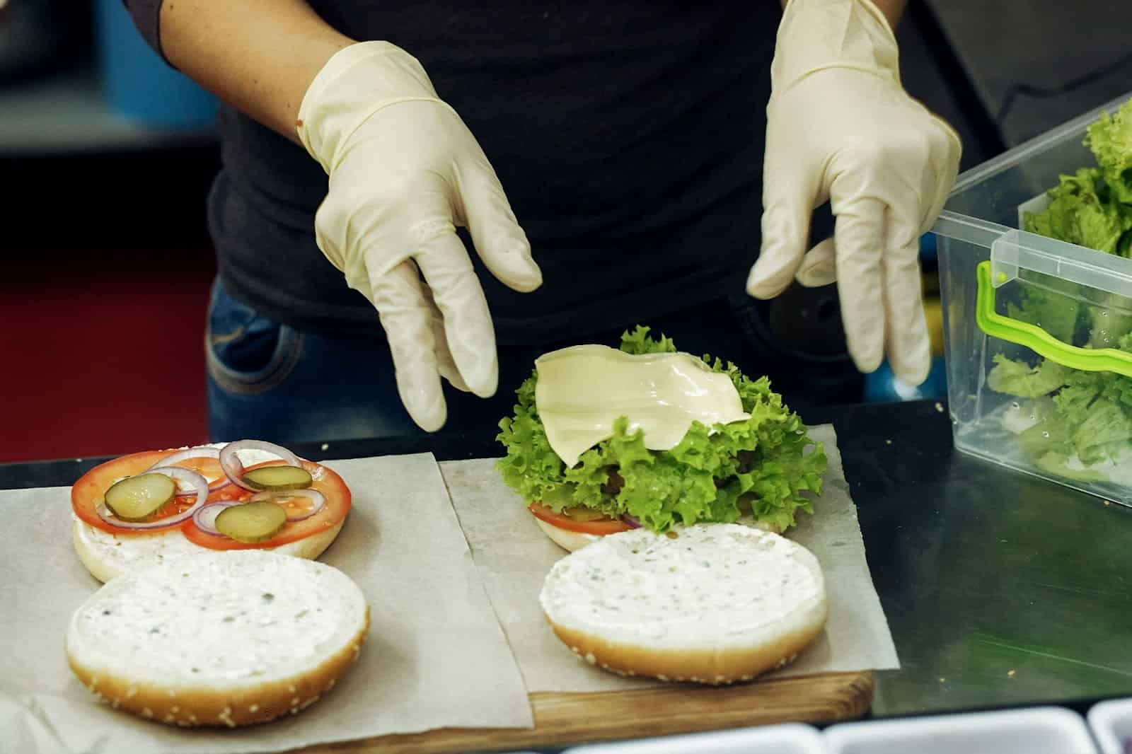 A person preparing a burger.