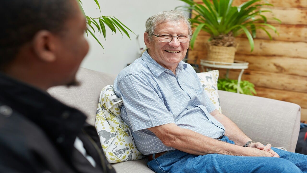 An older man and a younger man talking.