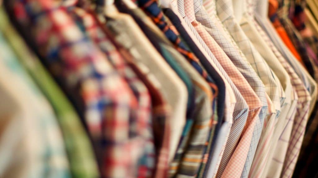 Patterned shirts hung on a shelf.