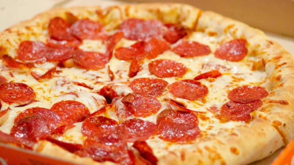 A pepperoni cheese pizza in an open box.